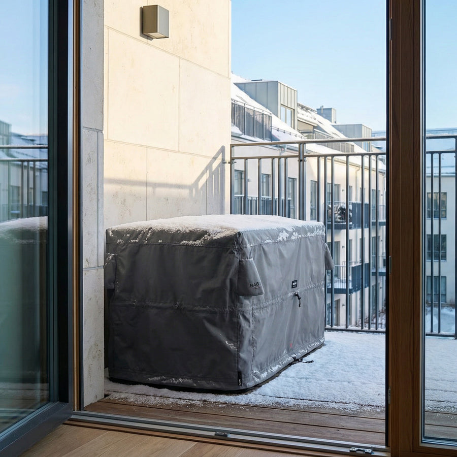 Bag'in på en altan med snedække, set gennem en glasdør. #Color_Dark-grey