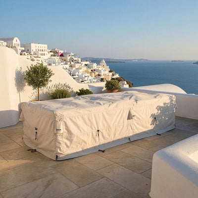 SunGuard outdoor furniture cover protecting a large seating set on a terrace with a coastal view, designed for sun and heat exposure.